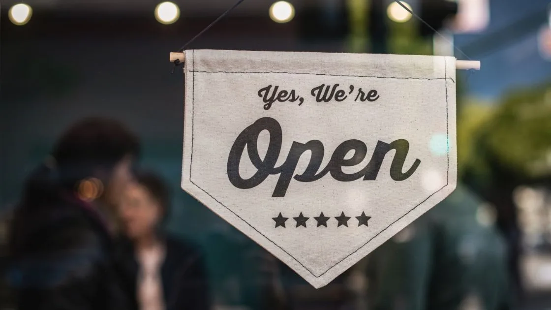 Yes We're Open sign hanging in a small business window in Copley, Ohio